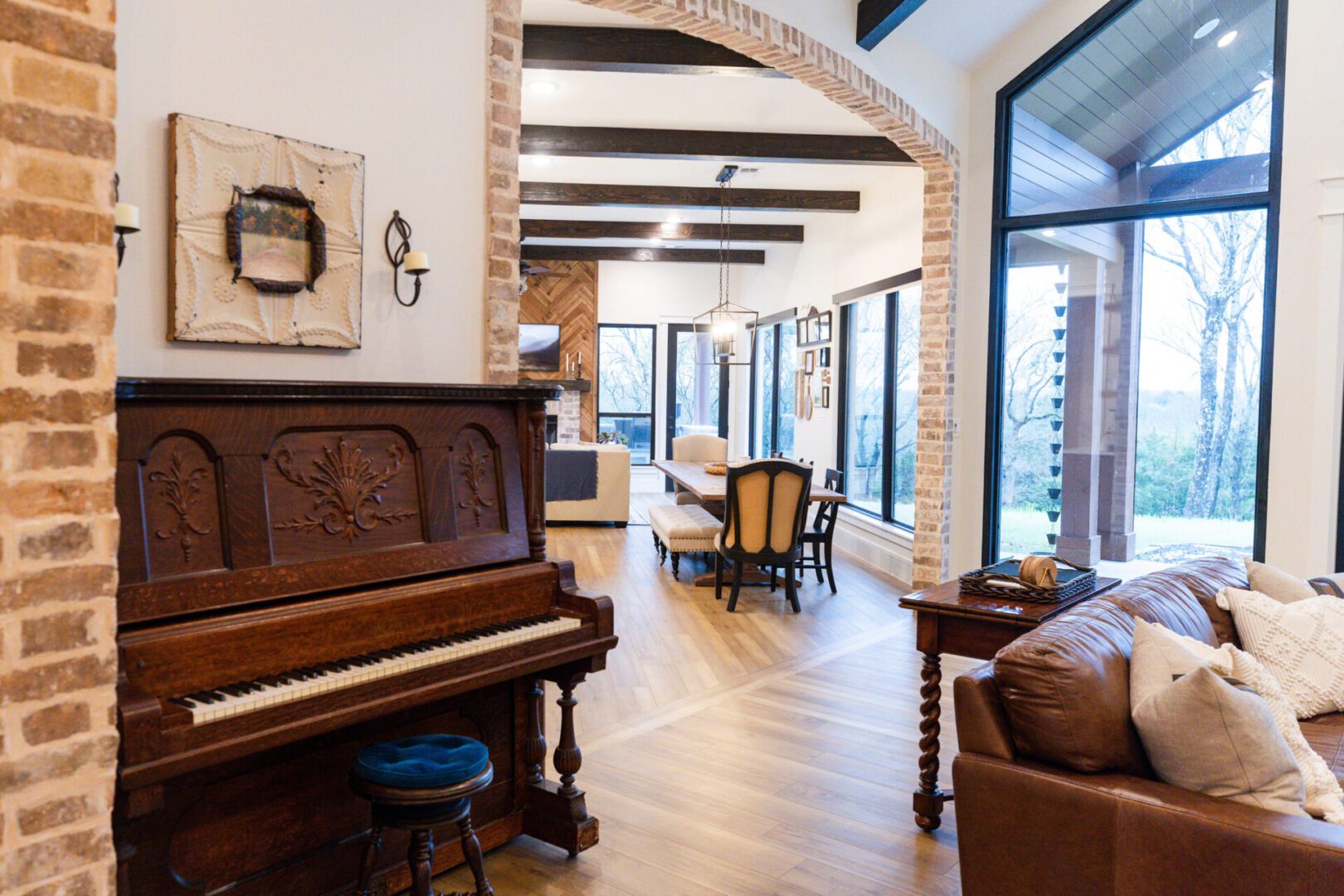 Open living room with piano and dining table.